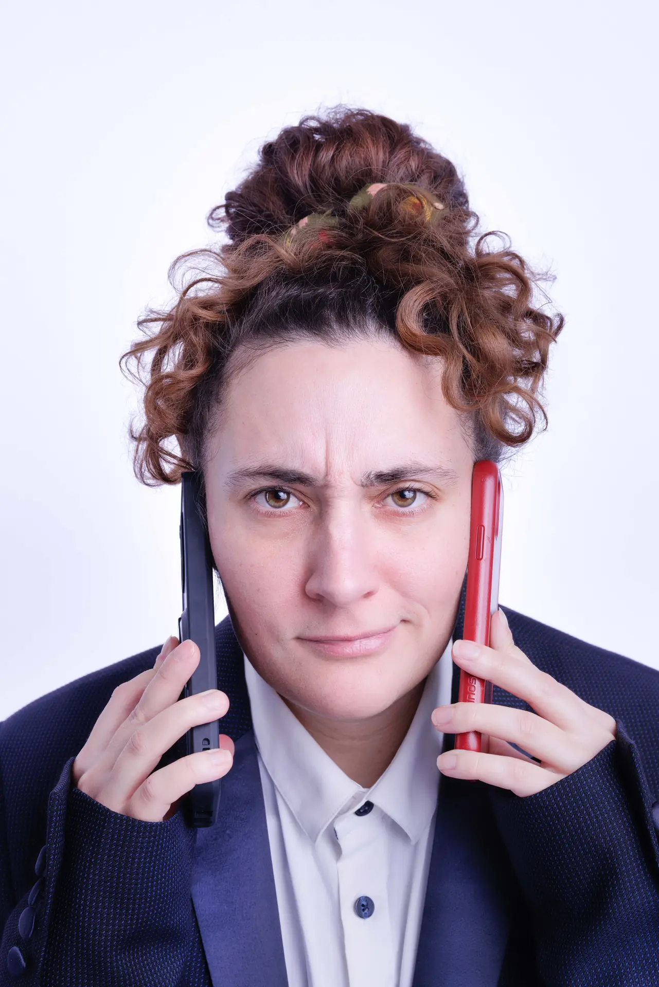 Assistante administrative avec deux téléphones, concentrée sur ses appels