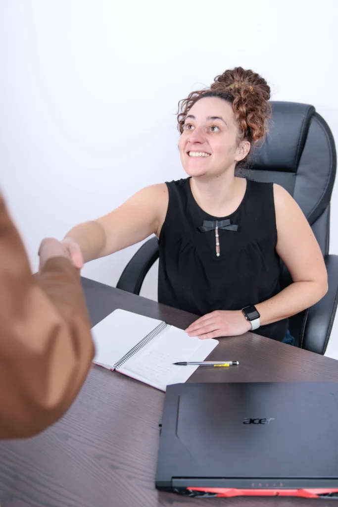 Assistante indépendante souriante serrant la main d’un client