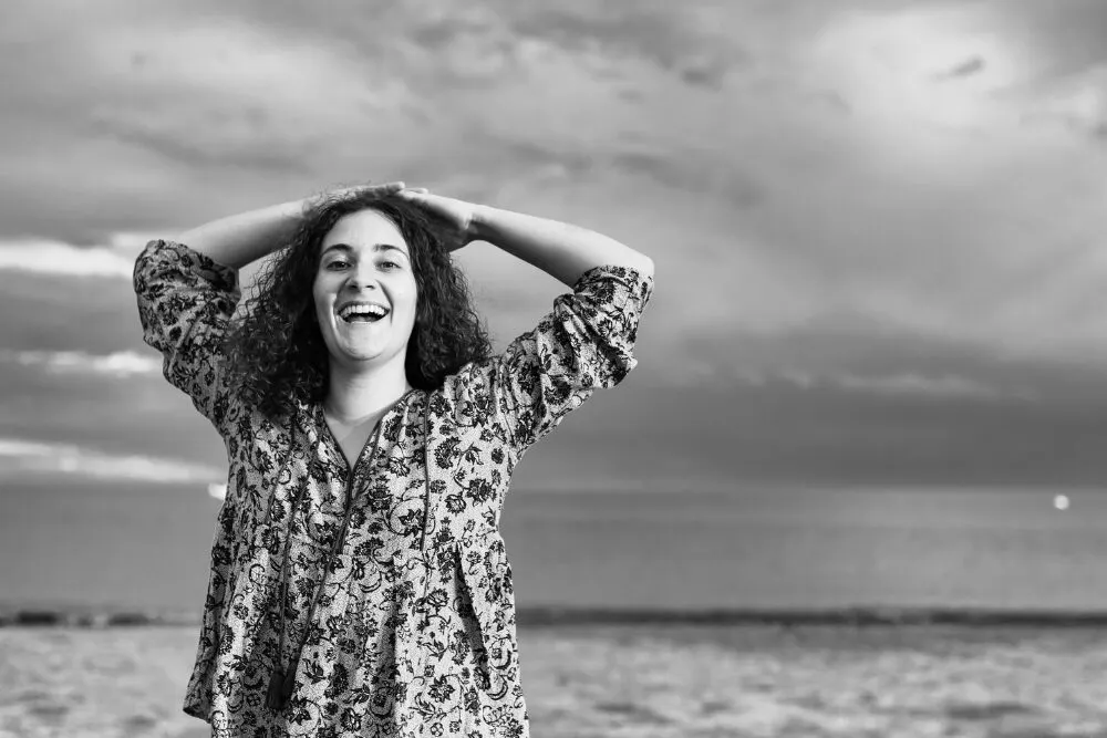 Femme souriante les mains derrière la tête, représentant une gestion administrative simplifiée et sereine